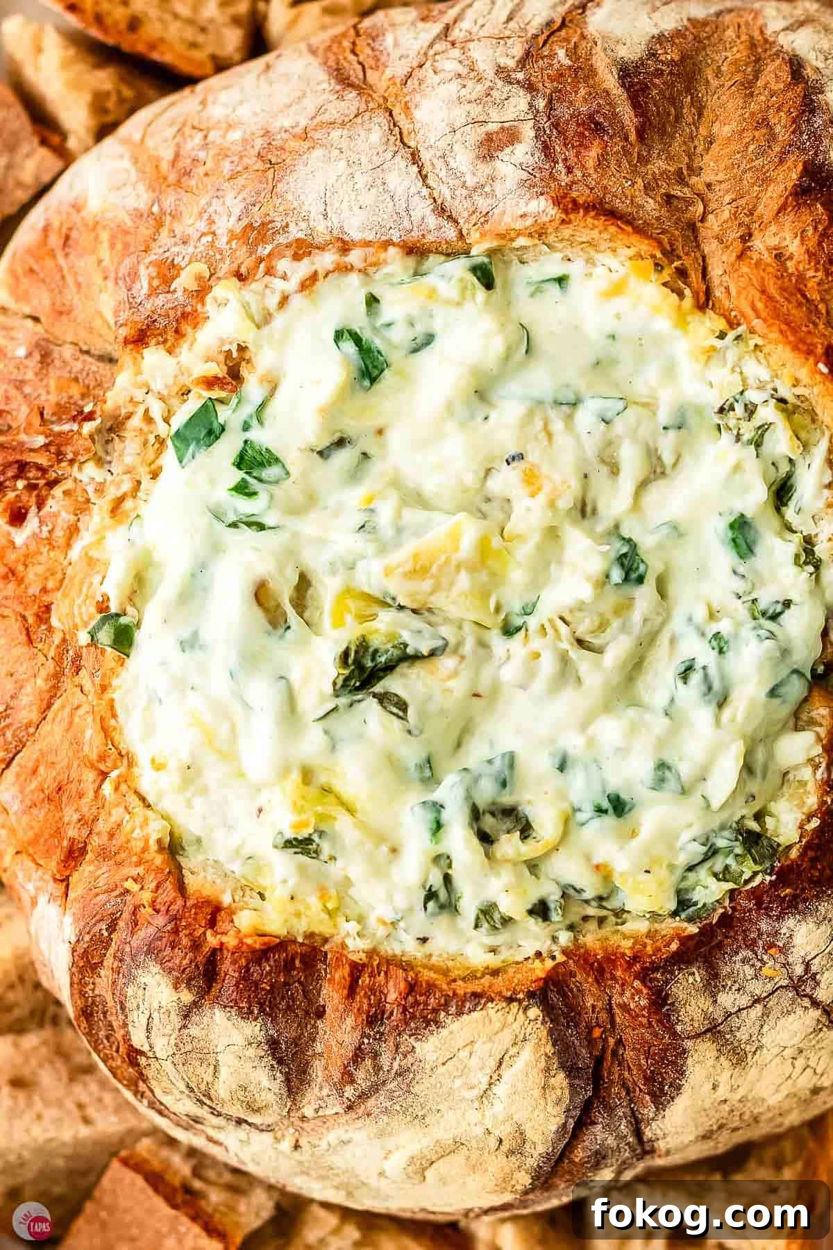 baked spinach artichoke dip in a sourdough bread loaf