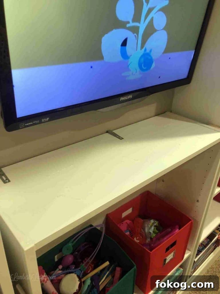 Built-In Bedroom Wardrobe Using IKEA Billy Bookcases 11 cabinet installed below tv, with metal braces.