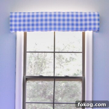 blue gingham cornice board hung above a window.