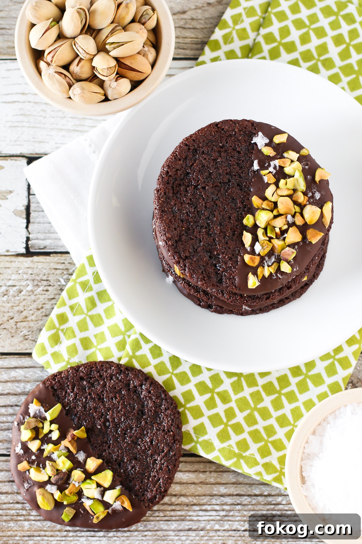 Grain Free Vegan Sea Salt Pistachio Chocolate Cookies. Chewy chocolate almond cookies, dipped in chocolate and sprinkled with chopped pistachios and sea salt.