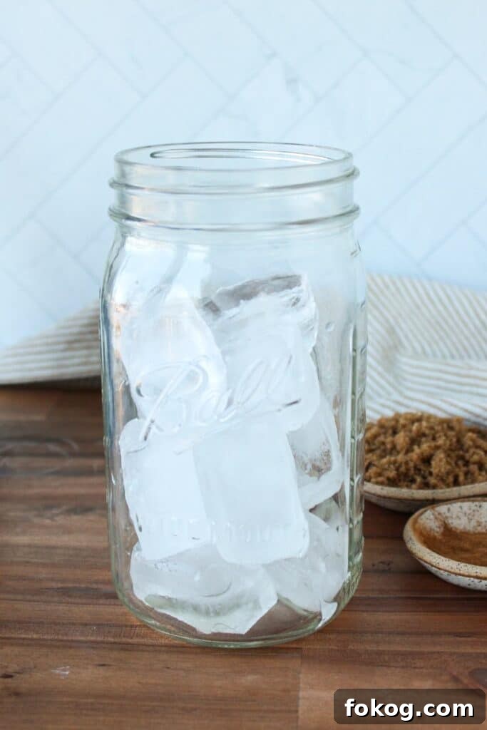 Iced Brown Sugar Latte Recipe — Creamy Cold Coffee Drink 4 A large mason jar full of ice cubes.