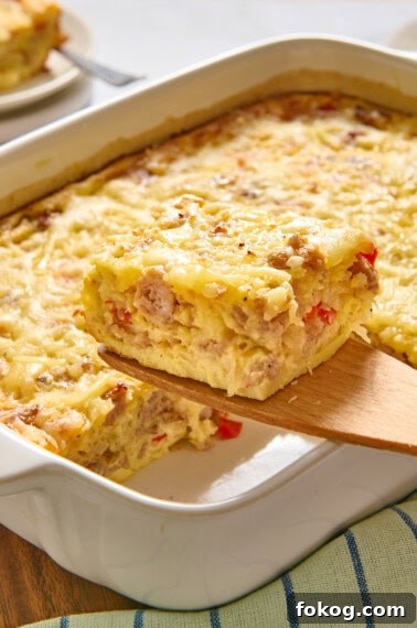 Festive Christmas Breakfast Casserole with Sausage and Cheese 13 Slice of Bisquick breakfast casserole on a wooden spatula.