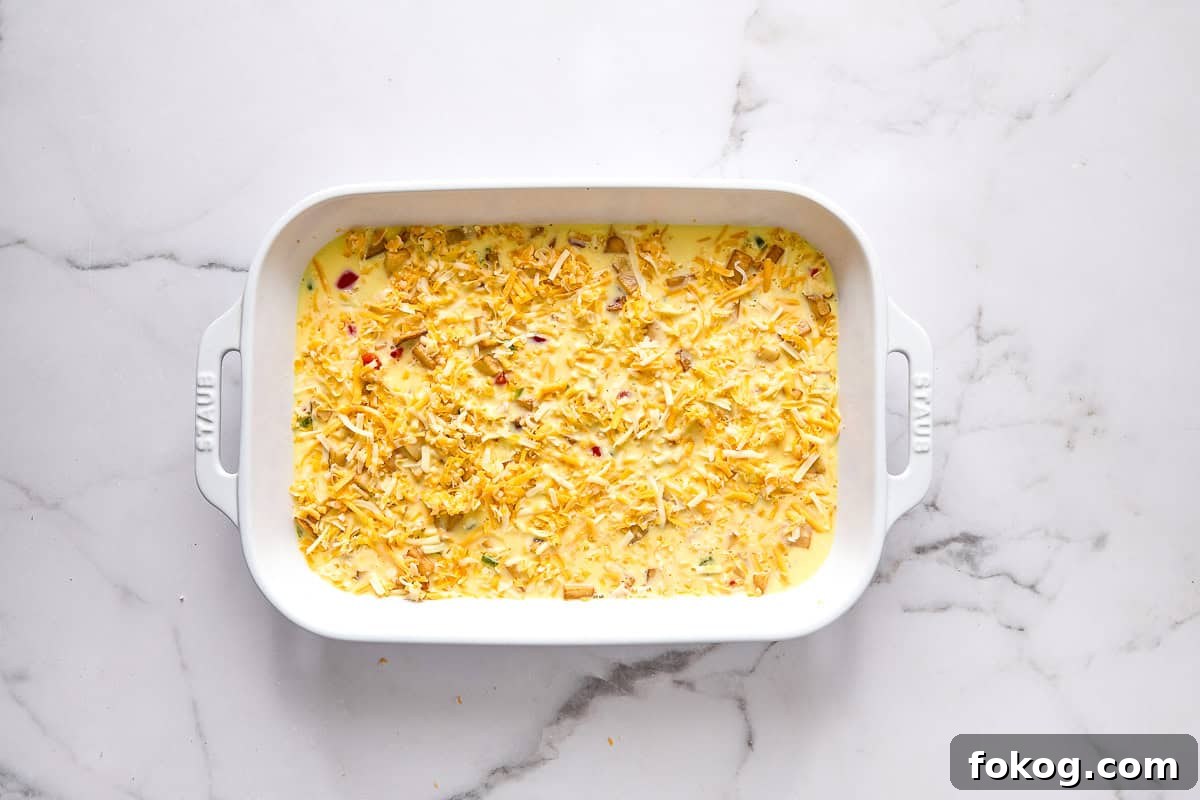Festive Christmas Breakfast Casserole with Sausage and Cheese 7 Christmas morning casserole in dish before baking.