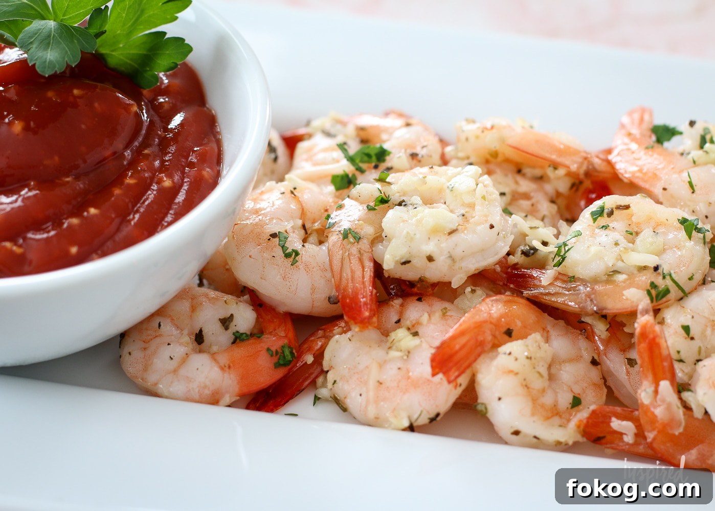 plated with roasted shrimp and a bowl of cocktail sauce.