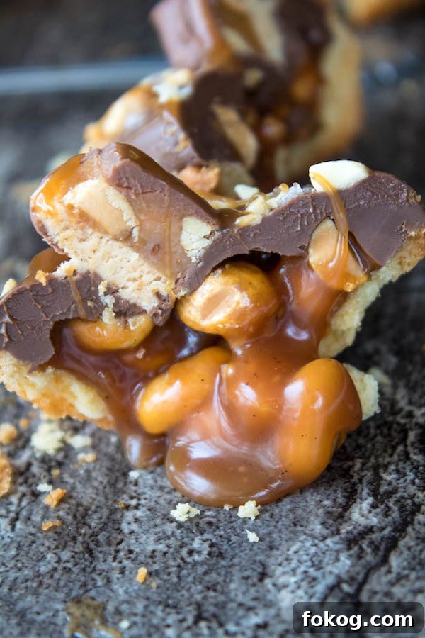 Mini Salted Caramel Snickers Tarts! Mini pre-baked tart shells with a salted caramel peanut filling and a chocolate peanut butter topping. Finish it off with chopped snickers and more peanuts, and you have the easiest/most decadent and delicious, bite-sized dessert!