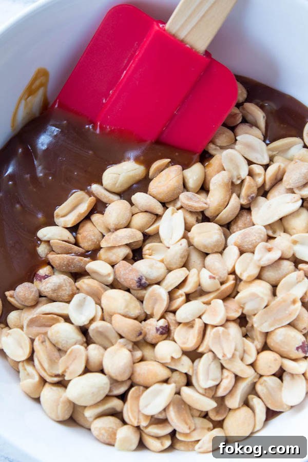 Mini Salted Caramel Snickers Tarts! Mini pre-baked tart shells with a salted caramel peanut filling and a chocolate peanut butter topping. Finish it off with chopped snickers and more peanuts, and you have the easiest/most decadent and delicious, bite-sized dessert!
