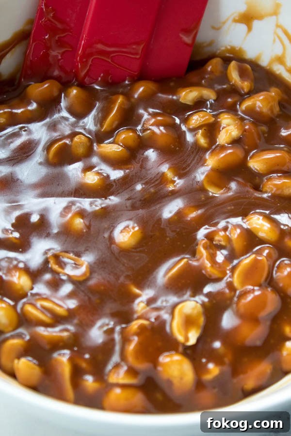 Mini Salted Caramel Snickers Tarts! Mini pre-baked tart shells with a salted caramel peanut filling and a chocolate peanut butter topping. Finish it off with chopped snickers and more peanuts, and you have the easiest/most decadent and delicious, bite-sized dessert!