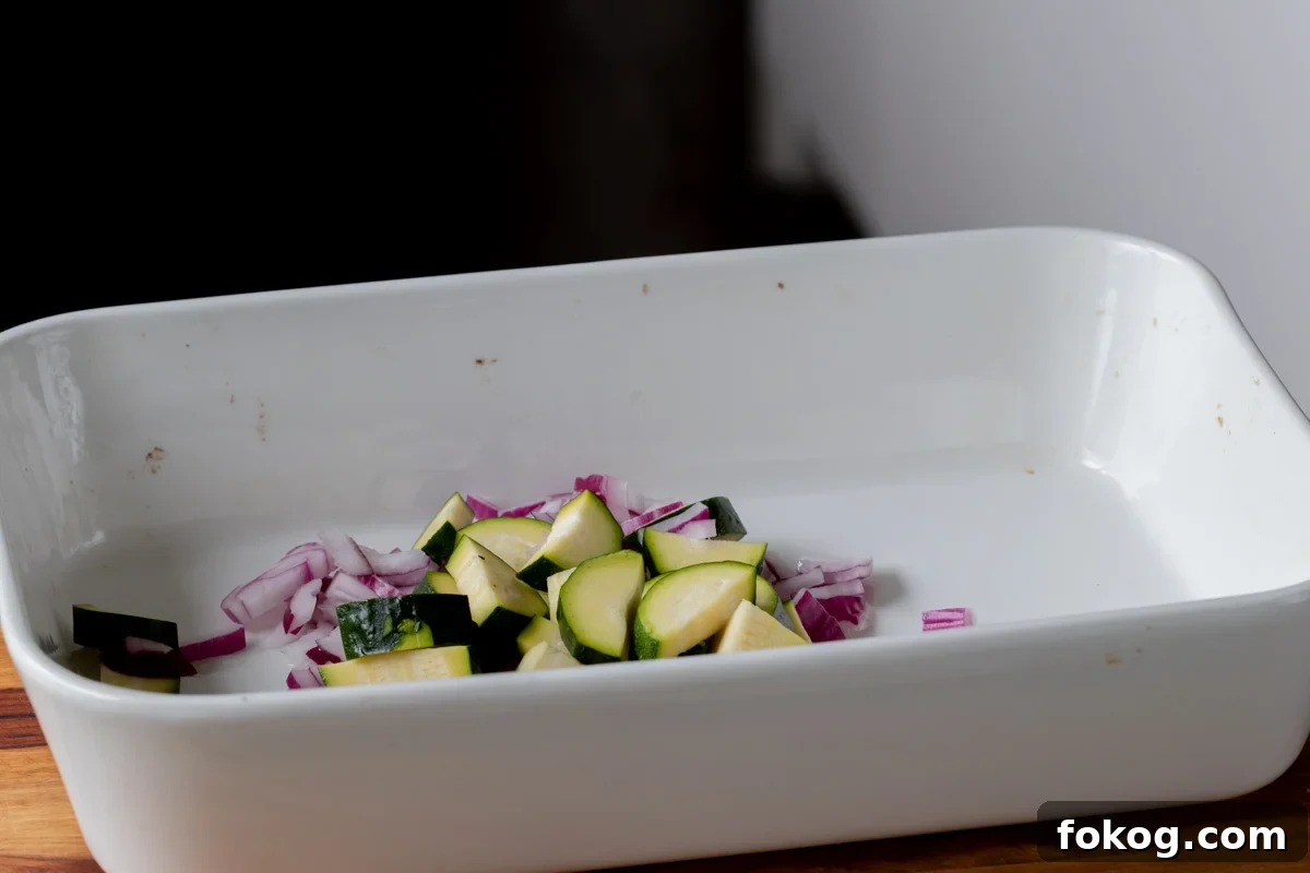 adding onion and zucchini to the pan