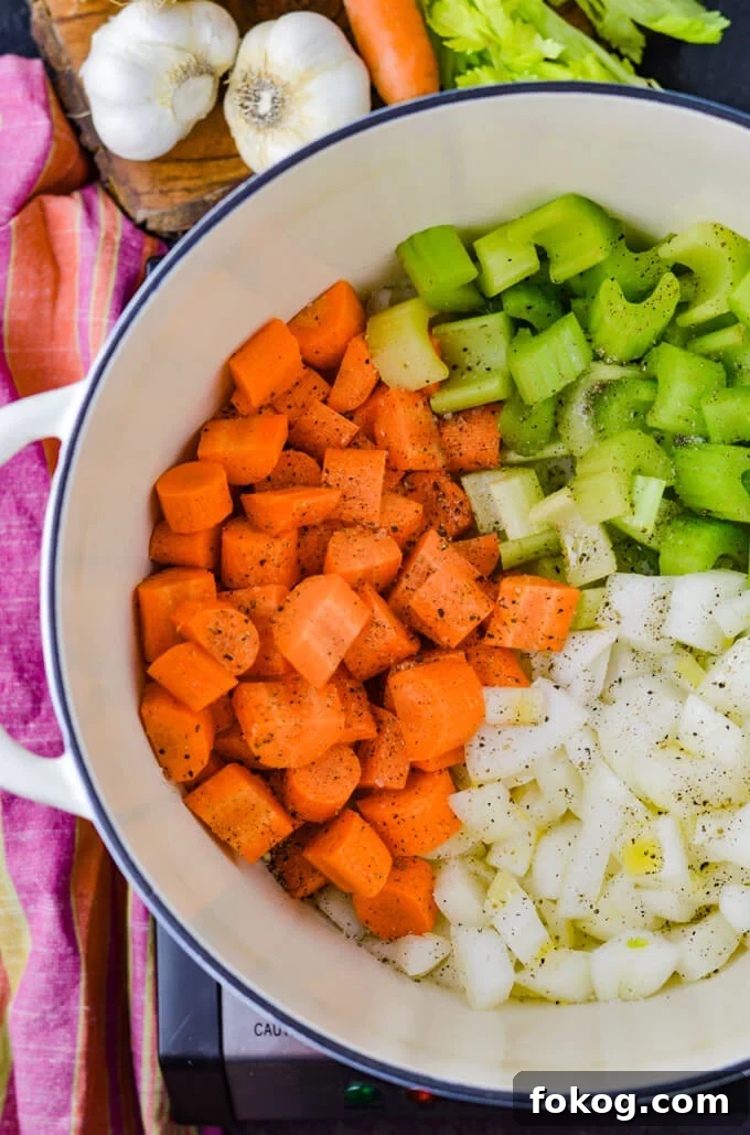 Hearty Chicken and Wild Rice Soup Recipe for Cozy Nights 4 A Dutch oven with raw carrots, celery and onions.