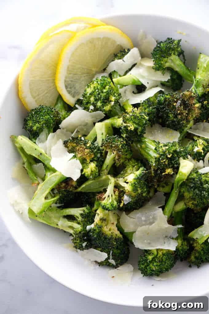 Broccoli in a bowl with parmesan and lemon.