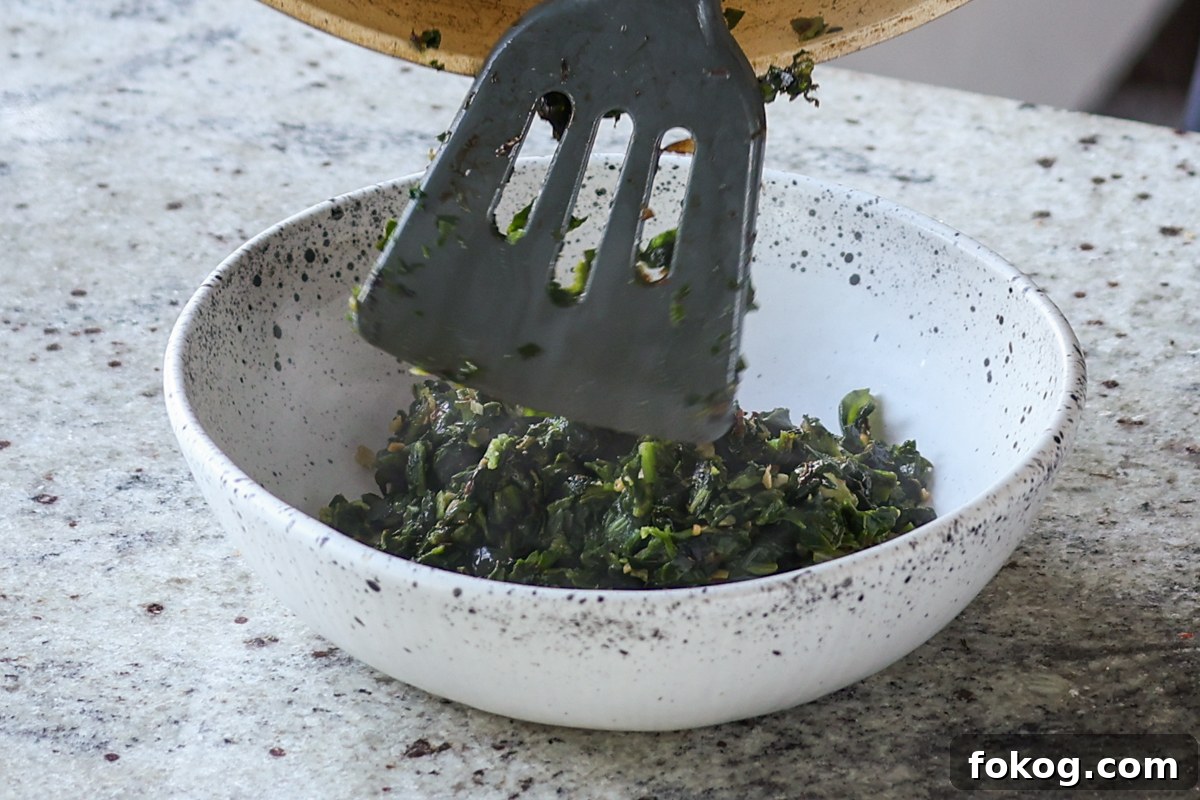 adding spinach mixture to a bowl