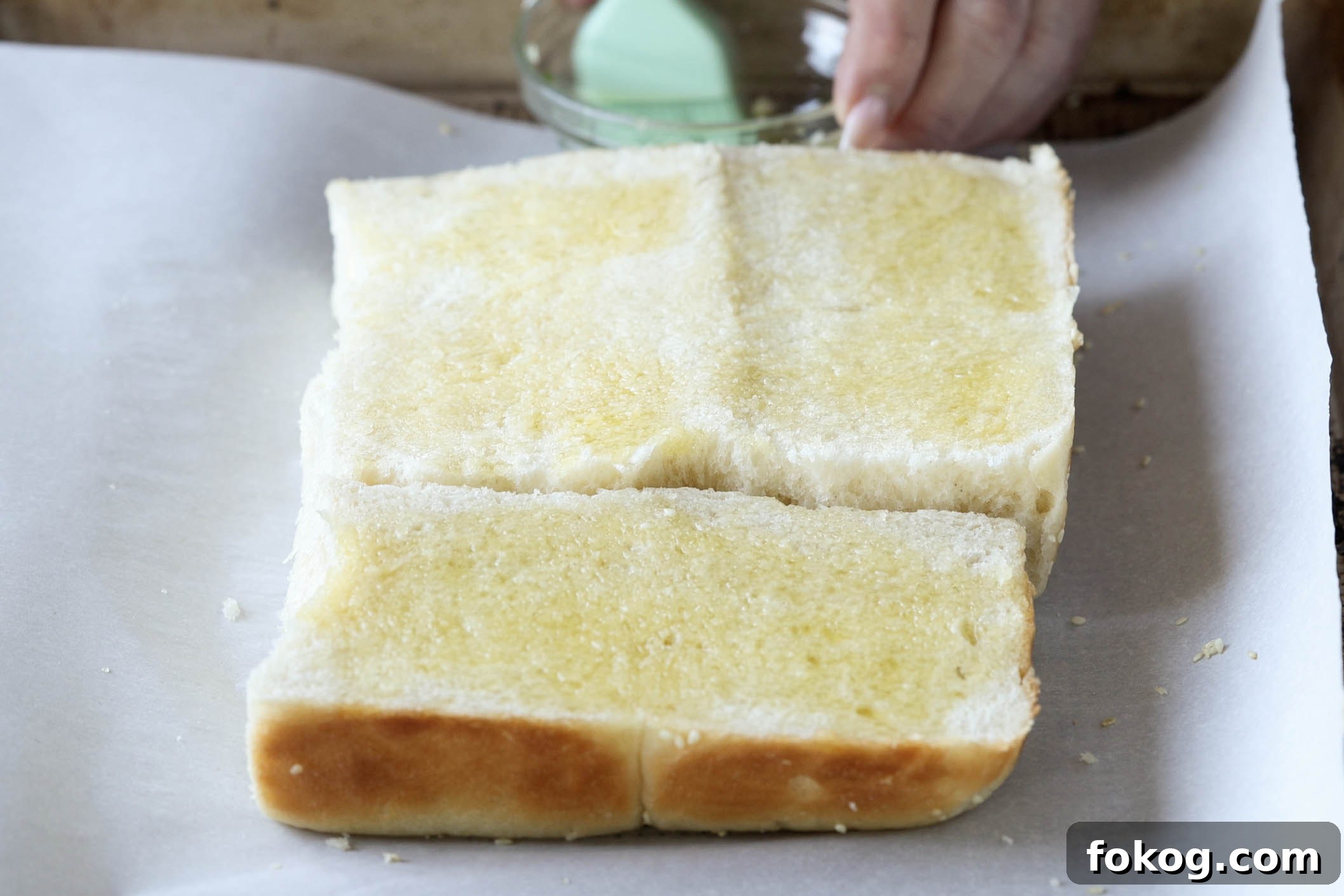 brushing olive oil onto the slider buns