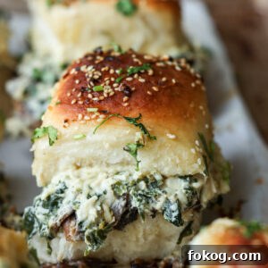 close-up of cheesy mushroom sliders on the baking sheet after baking