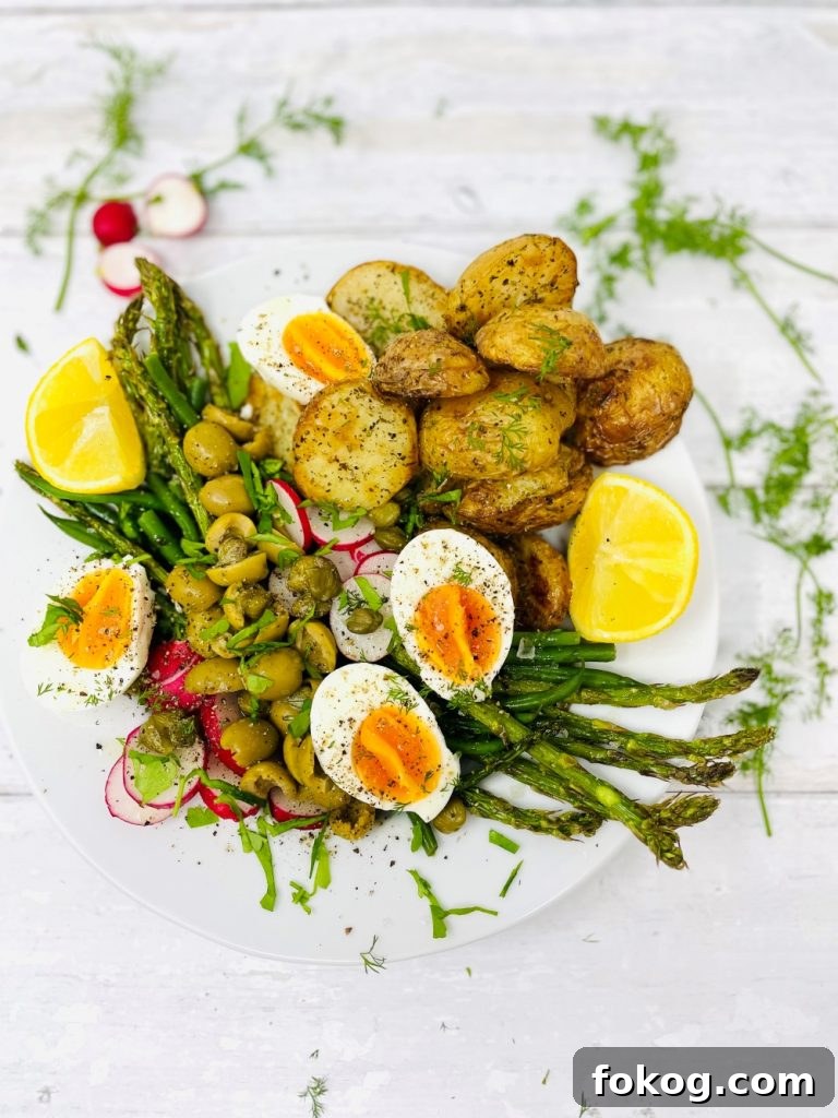 Light Summer Dinner Ideas: Quick Recipes for Warm Evenings 10 spring salad with boiled eggs, asparagus, new potatoes, radishes, green olives and lots of fresh herbs on a white plate