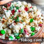 Popcorn snack mix in a copper tin on a white counter.