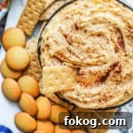Overhead shot of pumpkin dip in a black bowl on a white counter.