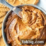 Overhead shot of cookie butter in a bowl with a silver knife in it.