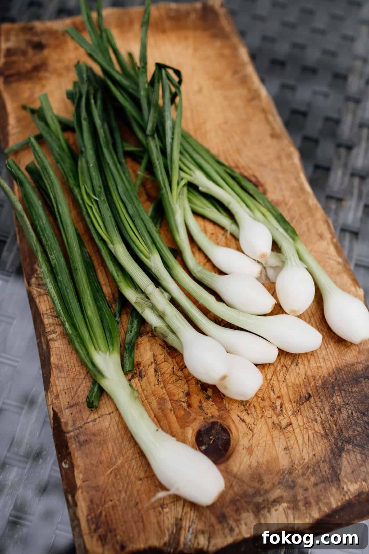 Grilled Spring Onions with Garlic Lime Butter 3 bunch of fresh spring onions on a wooden block