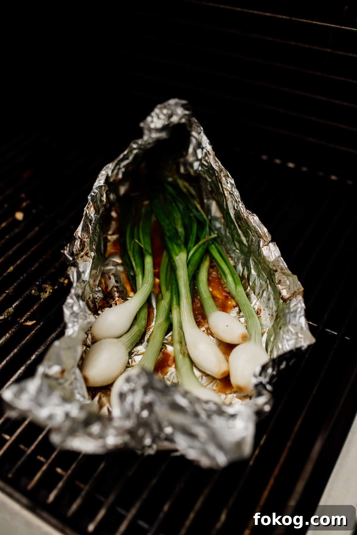 Grilled Spring Onions with Garlic Lime Butter 5 foil packet of green spring onions on the grill for making cebollitas asadas
