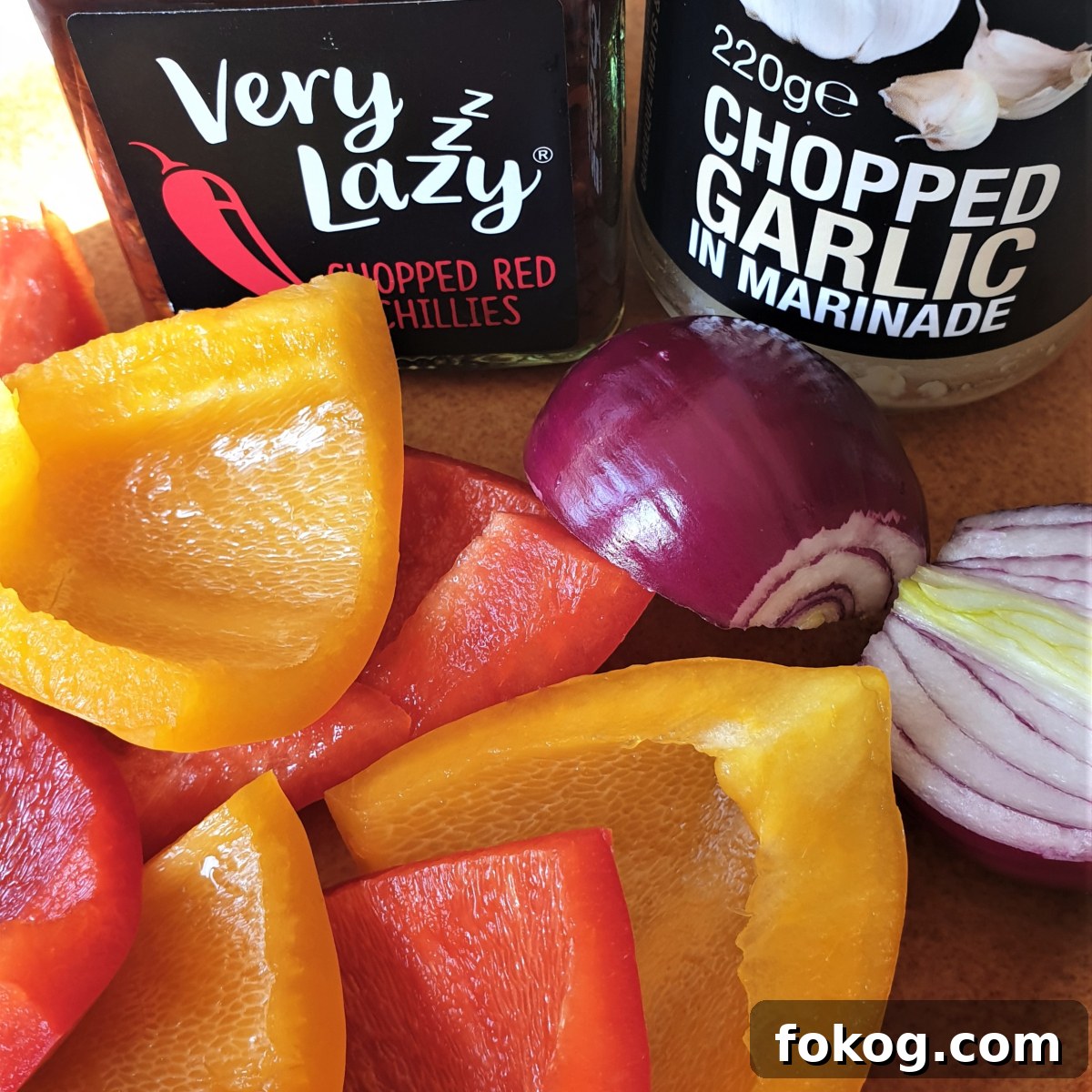 Chopped red and yellow peppers with a red onion and 2 jars of chilli and garlic.