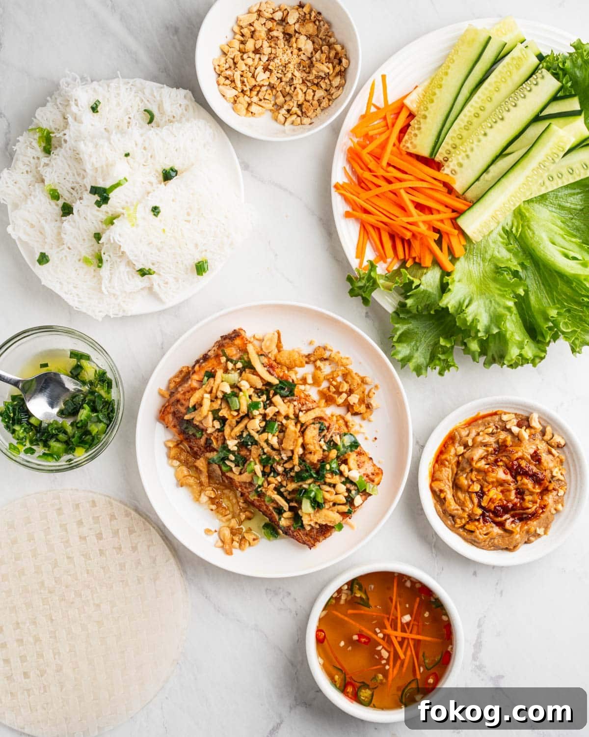 all ingredients for salmon spring roll. Salmon, noodles, veggies, and sauces.