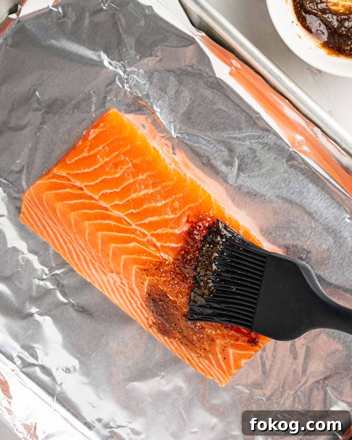 brushing salmon with seasoning.