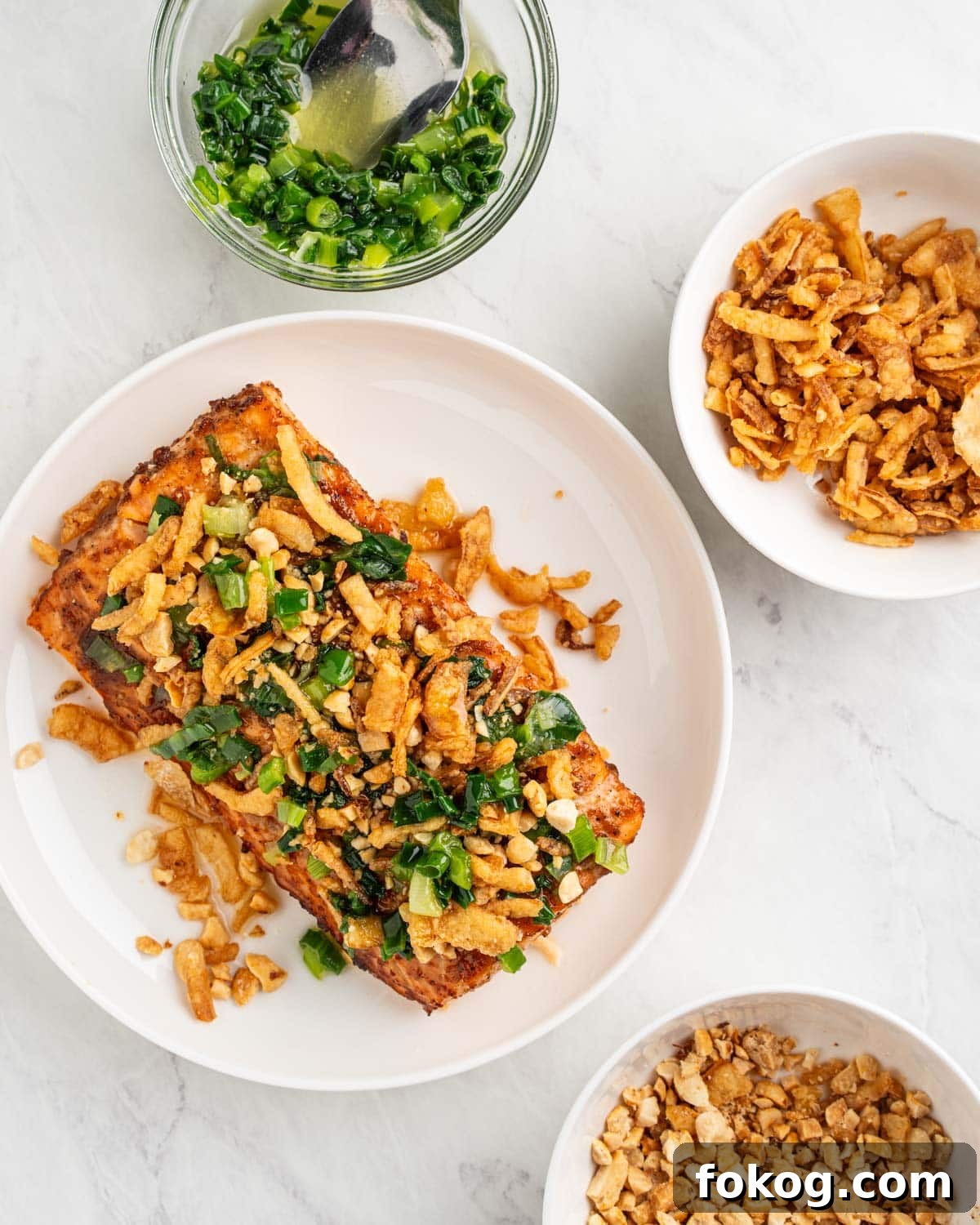 Baked salmon topped with crushed peanuts, scallion oil and fried onions.