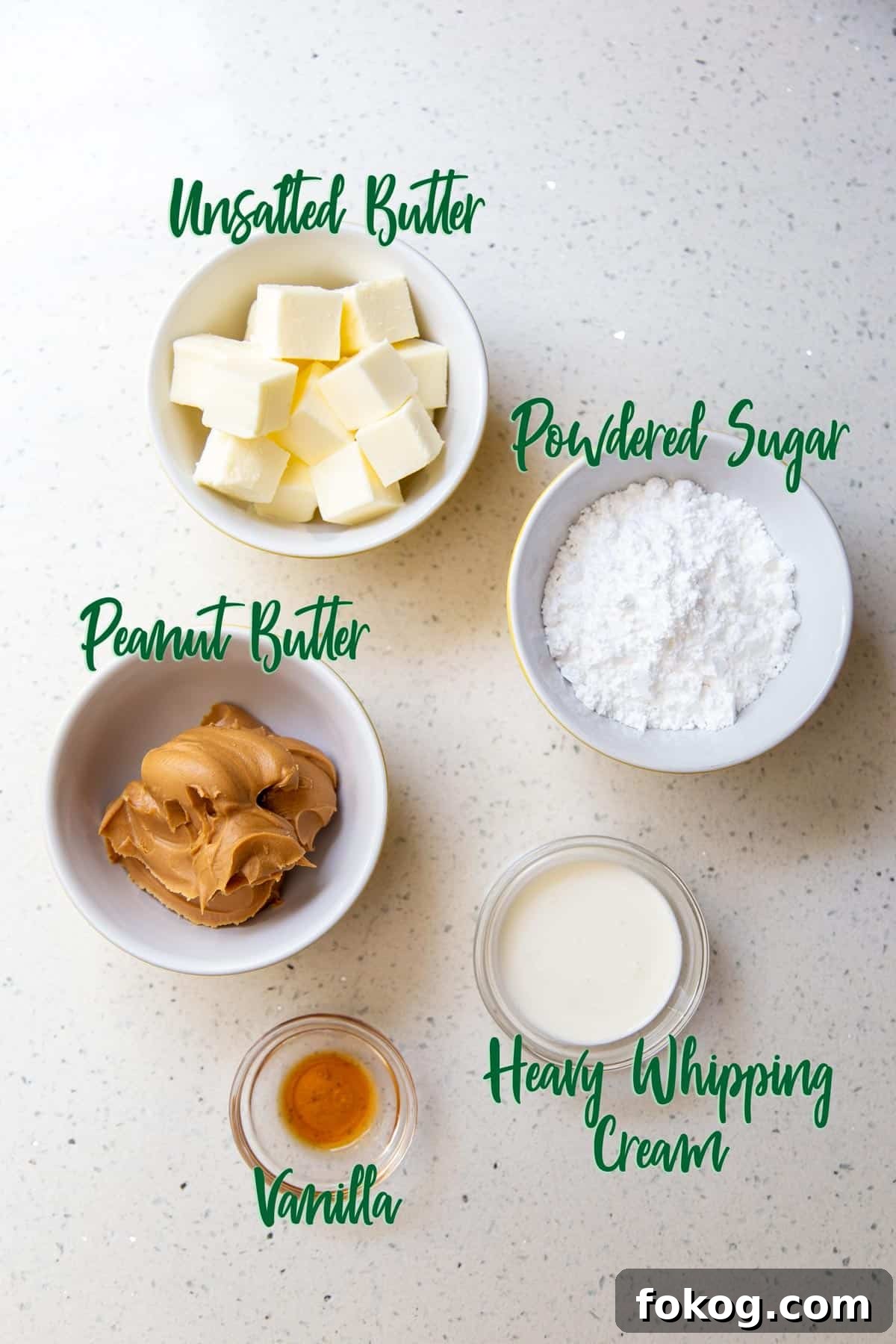 Ingredients for frosting in bowls on a white countertop