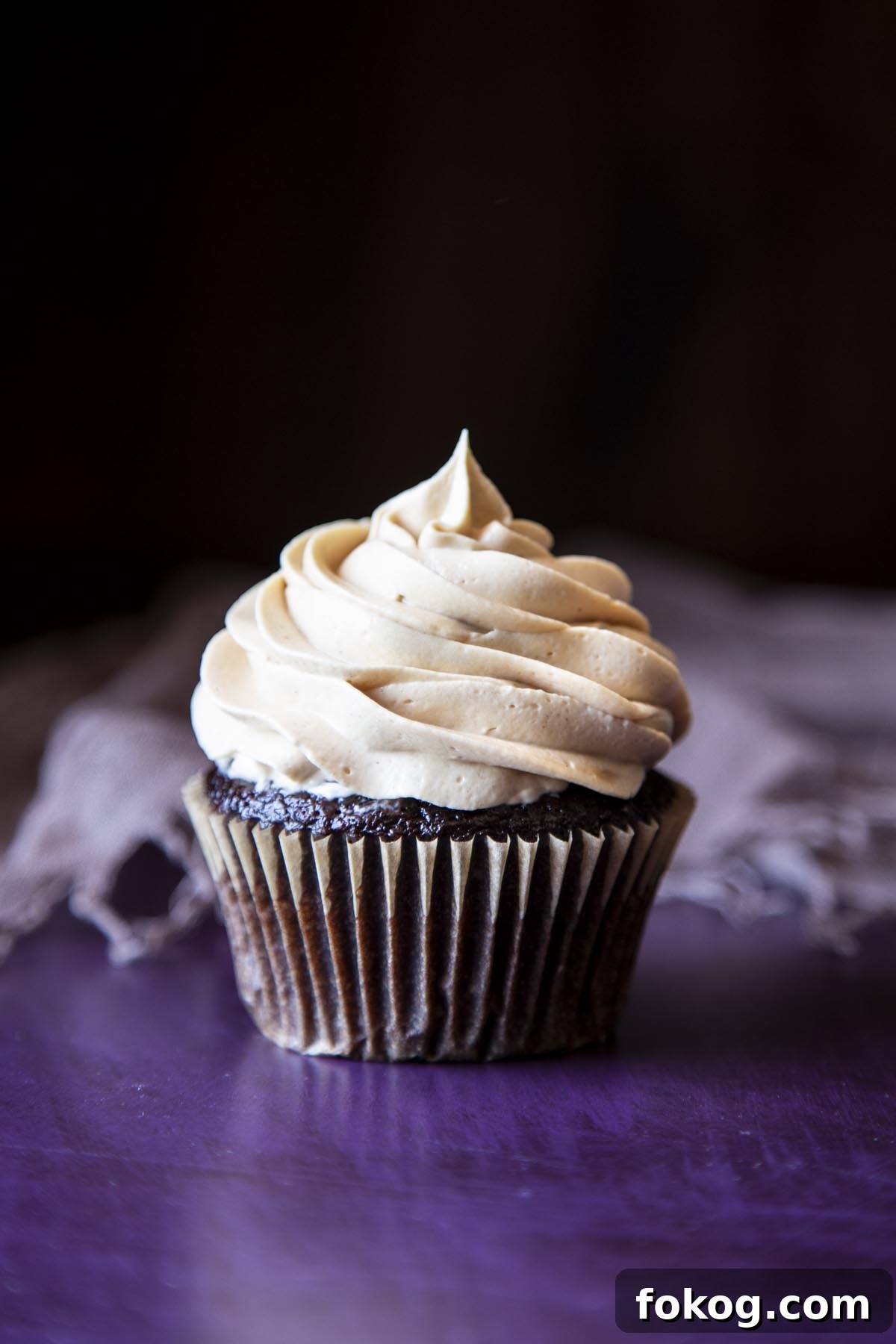 A chocolate cupcake with peanut butter frosting on top