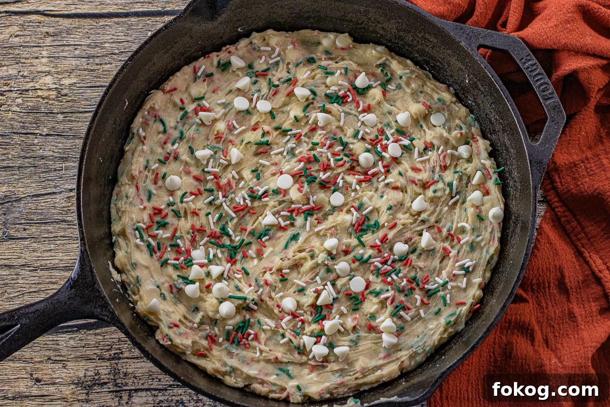 Cast Iron Skillet Christmas Sprinkle Cookies: Festive Holiday Recipe 6 uncooked cookie dough with red and green sprinkles in a cast iron skillet