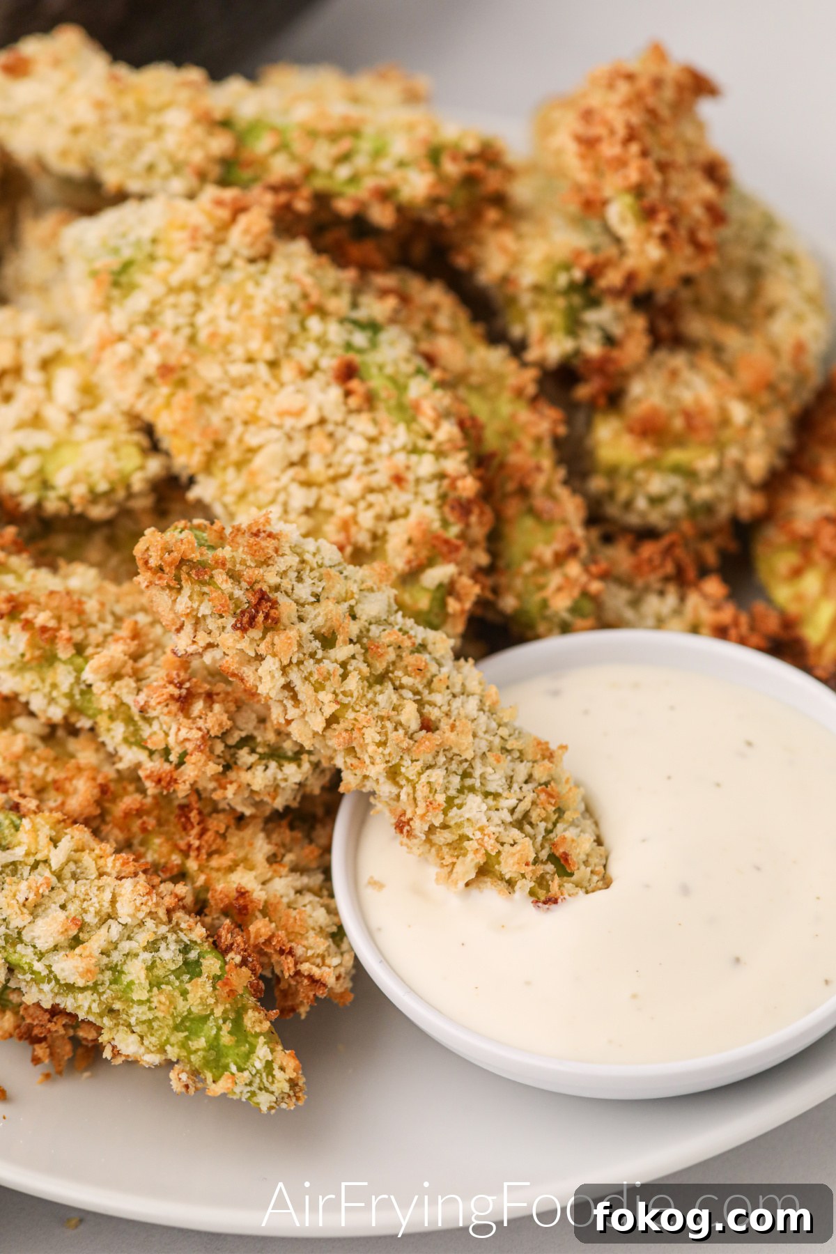 Air fried avocado fried cooked and served with a dipping sauce, ready to eat.