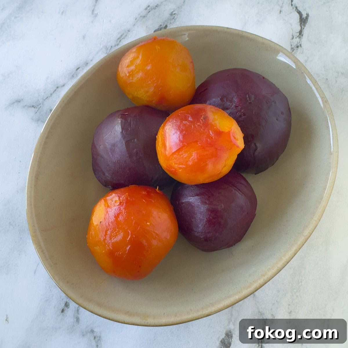 An oval bowl with roasted red and gold beets ready to enjoy.