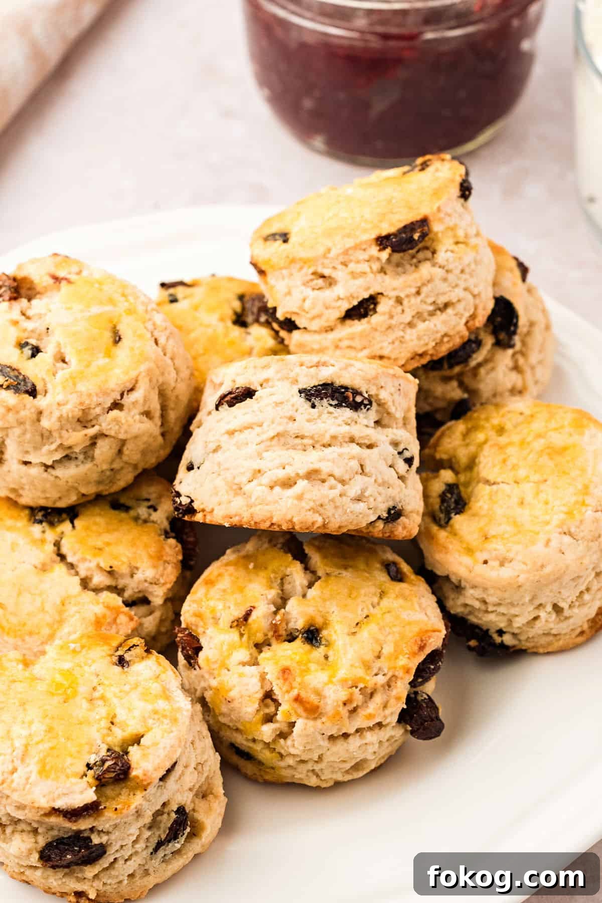 Pile of English raisin scones on a white plate.