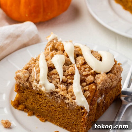 Detailed close-up of the moist crumb texture of gluten-free pumpkin coffee cake topped with streusel and glaze.