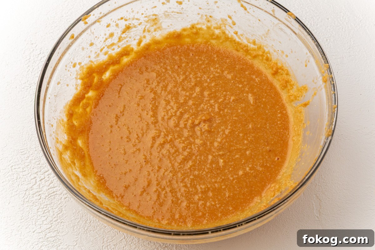 Smooth orange pumpkin batter after mixing wet ingredients for gluten-free pumpkin coffee cake.