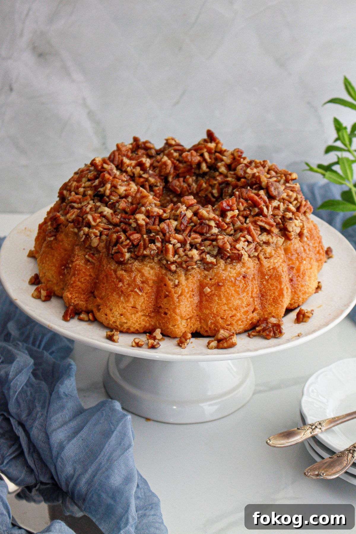 uncut pecan upside down cake on a cake stand.