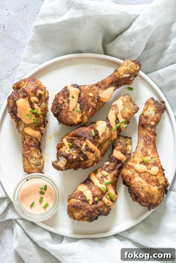 41 Juicy Chicken Drumstick Recipes You’ll Want Tonight 14 Air Fryer Chicken Drumsticks on a white plate with dipping sauce