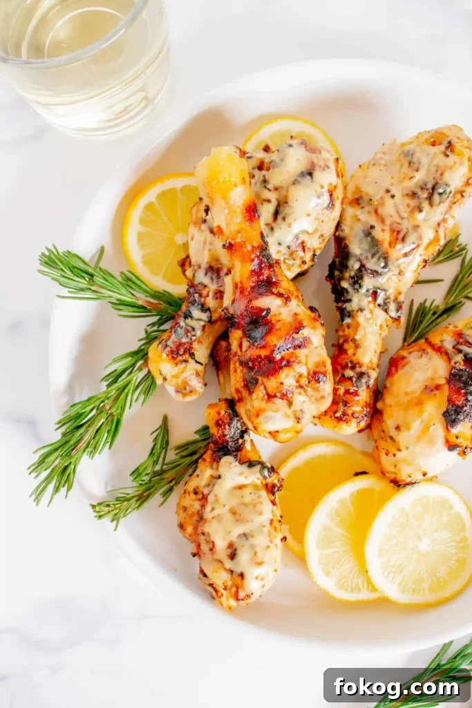 41 Juicy Chicken Drumstick Recipes You’ll Want Tonight 16 Grilled Honey Mustard Chicken Drumsticks on a white plate with sliced lemon and rosemary