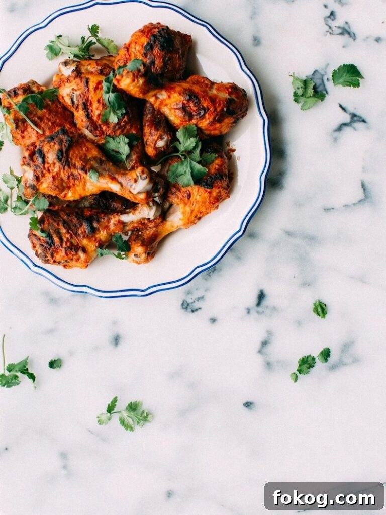 41 Juicy Chicken Drumstick Recipes You’ll Want Tonight 3 Tandoori chicken drumsticks on a white plate