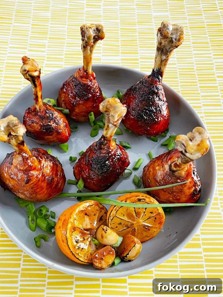 41 Juicy Chicken Drumstick Recipes You’ll Want Tonight 23 Lollipop Chicken Drumsticks served on a plate with lime wedges and scallions
