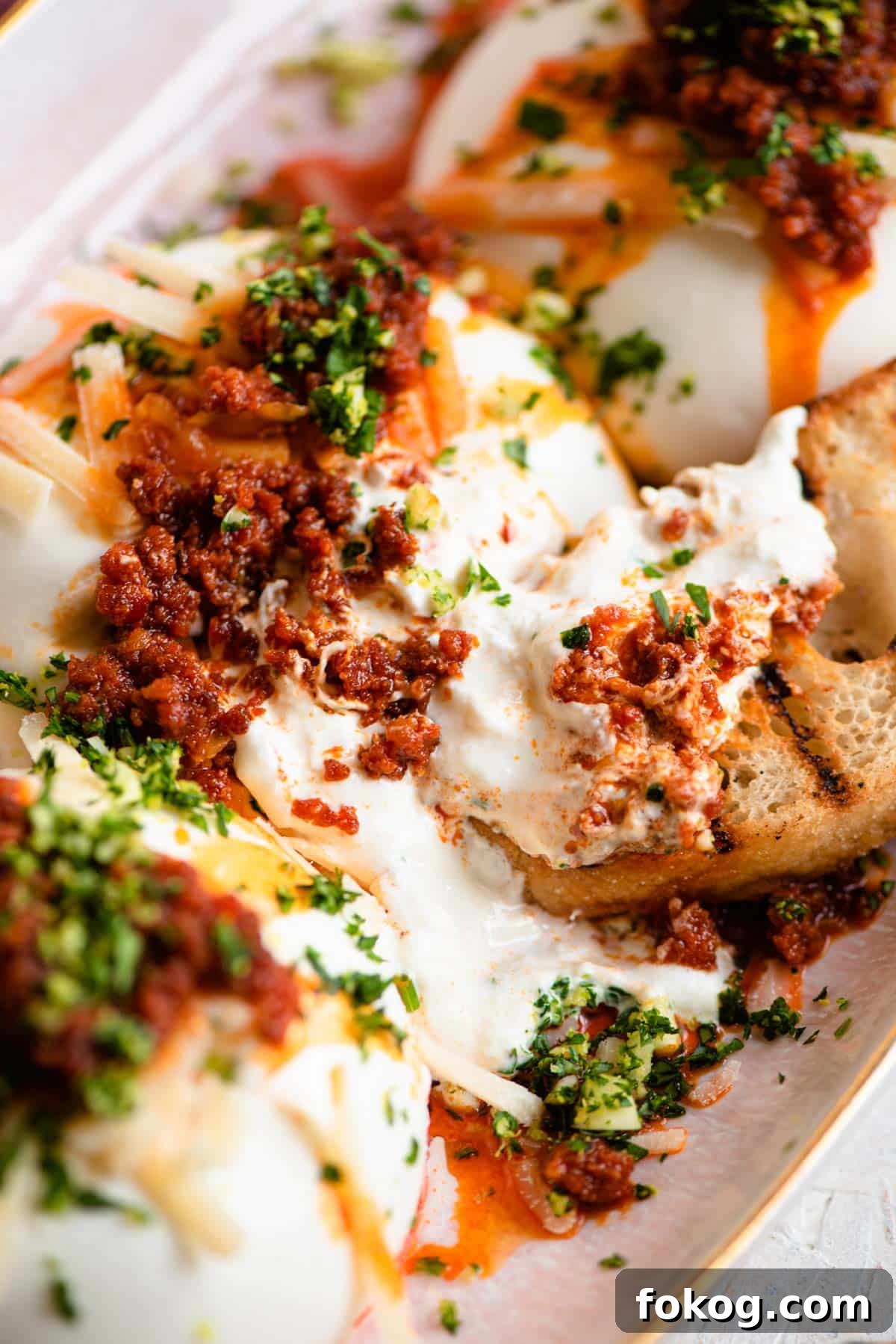 A close up of burrata cheese with 'Nduja and ciabatta bread