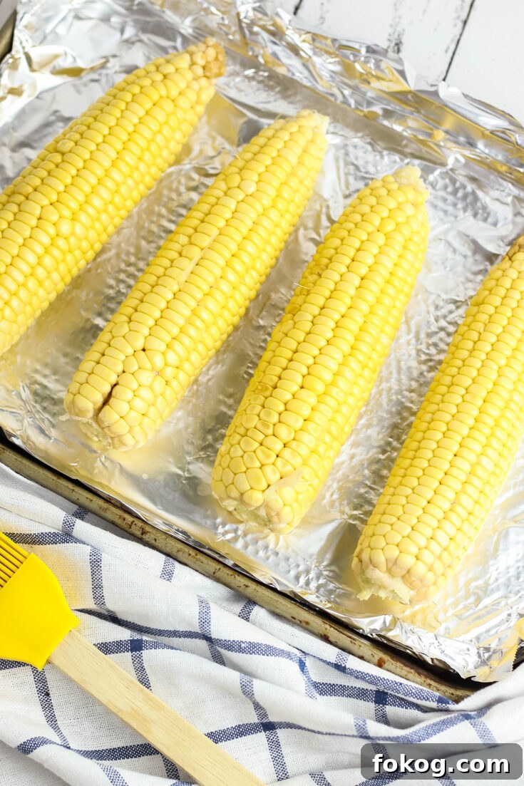Shucked corn on the cob on baking sheet