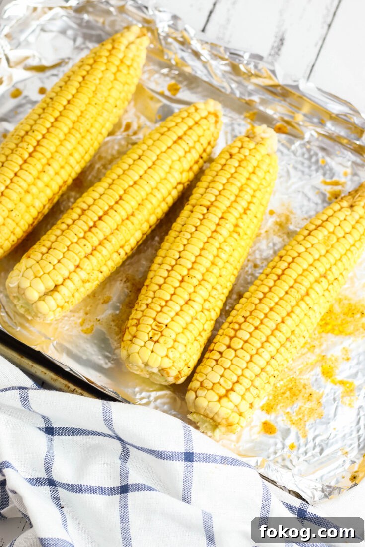 Corn on the cob brushed with Cajun Seasoning on baking sheet