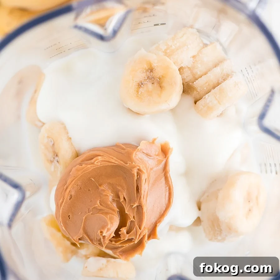 Salty & sweet peanut butter and banana smoothie makes a satisfying breakfast or afternoon snack, packed with protein and flavor! Ingredients in blender to make banana peanut butter smoothie.