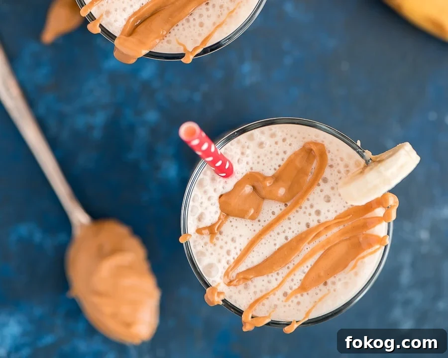 Salty & sweet peanut butter and banana smoothie makes a satisfying breakfast or afternoon snack, packed with protein and flavor! Peanut Butter and Banana Smoothie in a glass with peanut butter drizzle.