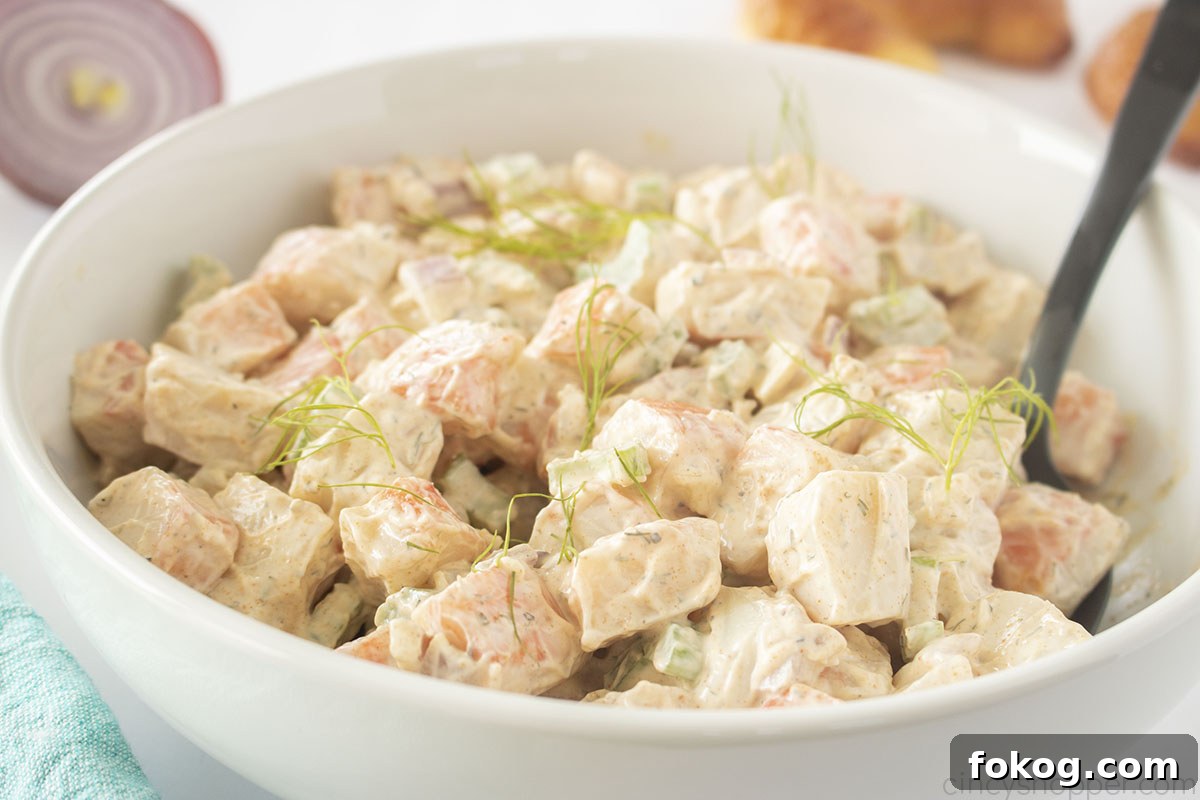 Crab Salad for sandwiches in a white bowl with a black spoon.