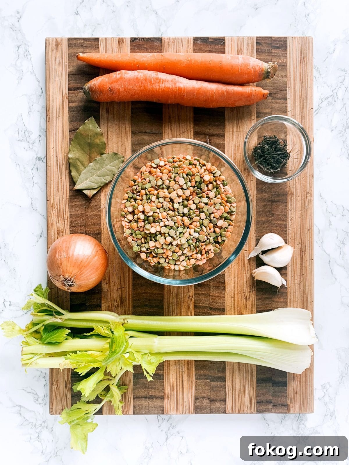 A cutting board topped with the ingredients for making vegan split pea soup.