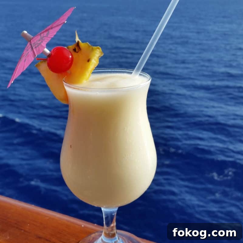 24+ Tropical Pineapple Juice Cocktail Recipes 14 Caribbean Colada in a hurricane glass with pineapple wedge and cherry garnish