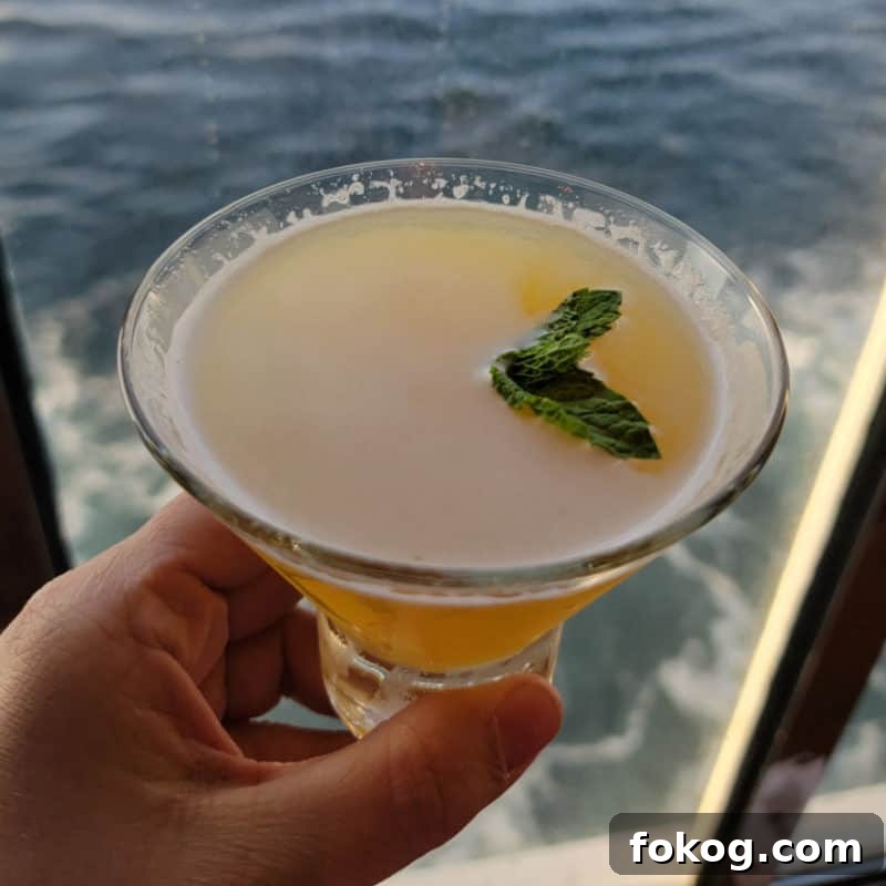 24+ Tropical Pineapple Juice Cocktail Recipes 15 Spicy Chipotle martini in a stemless martini glass with ocean water in the background