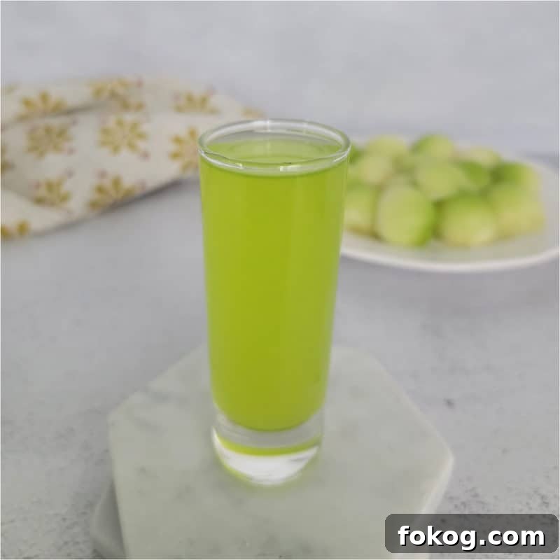 24+ Tropical Pineapple Juice Cocktail Recipes 3 Melon Ball Shot on a white coaster next to a plate of melon